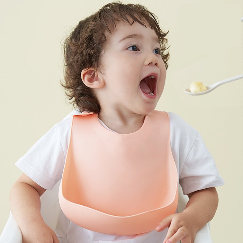 Toddler wearing silicone baby bib during feeding